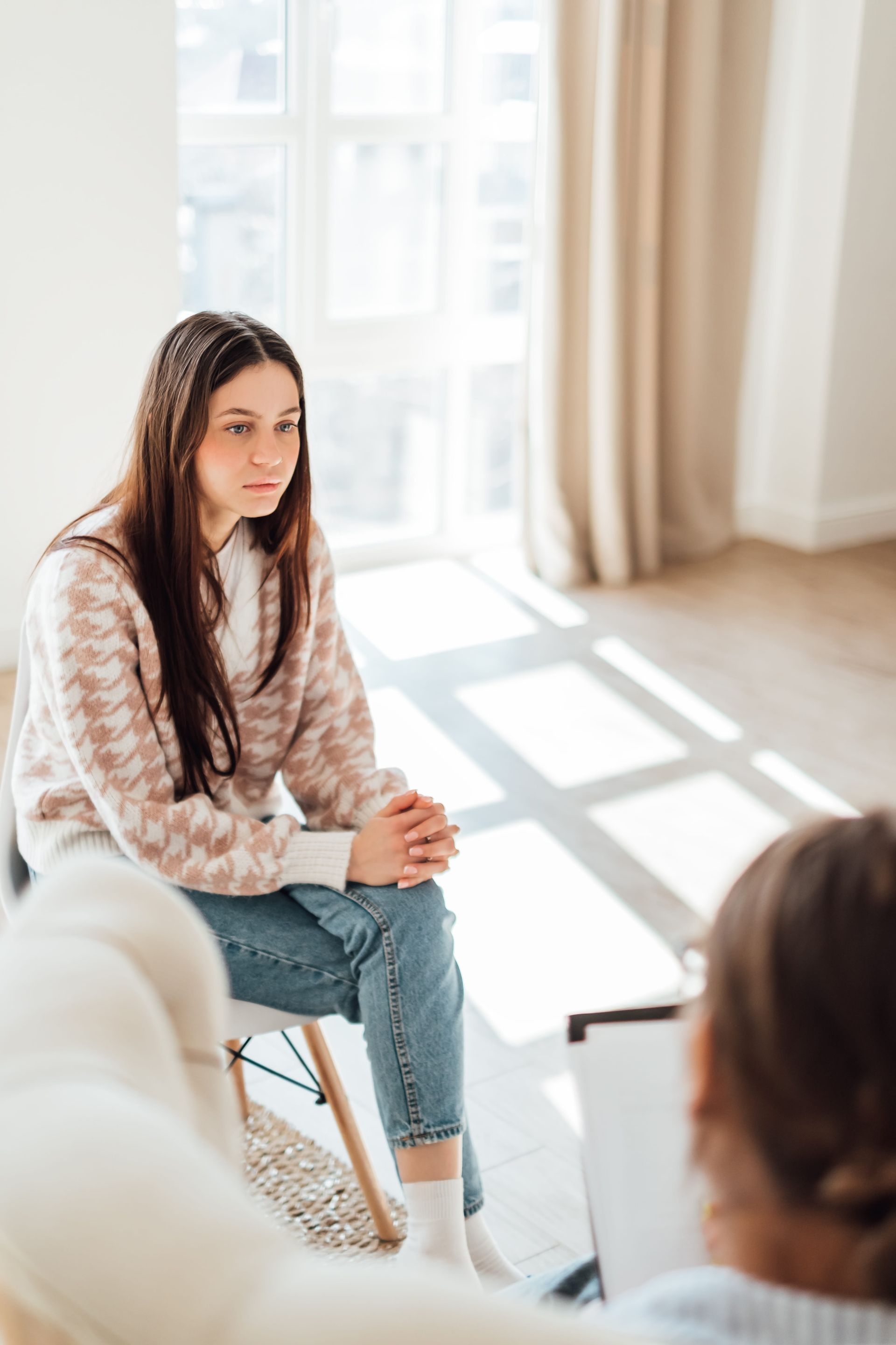 A teen sitting across from a counselor in a calm, welcoming Centreville, VA office during grief