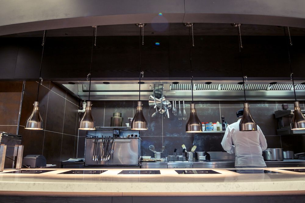 Chef Is Standing Behind A Counter In A Kitchen — Cater Tech Mackay In Mackay, QLD