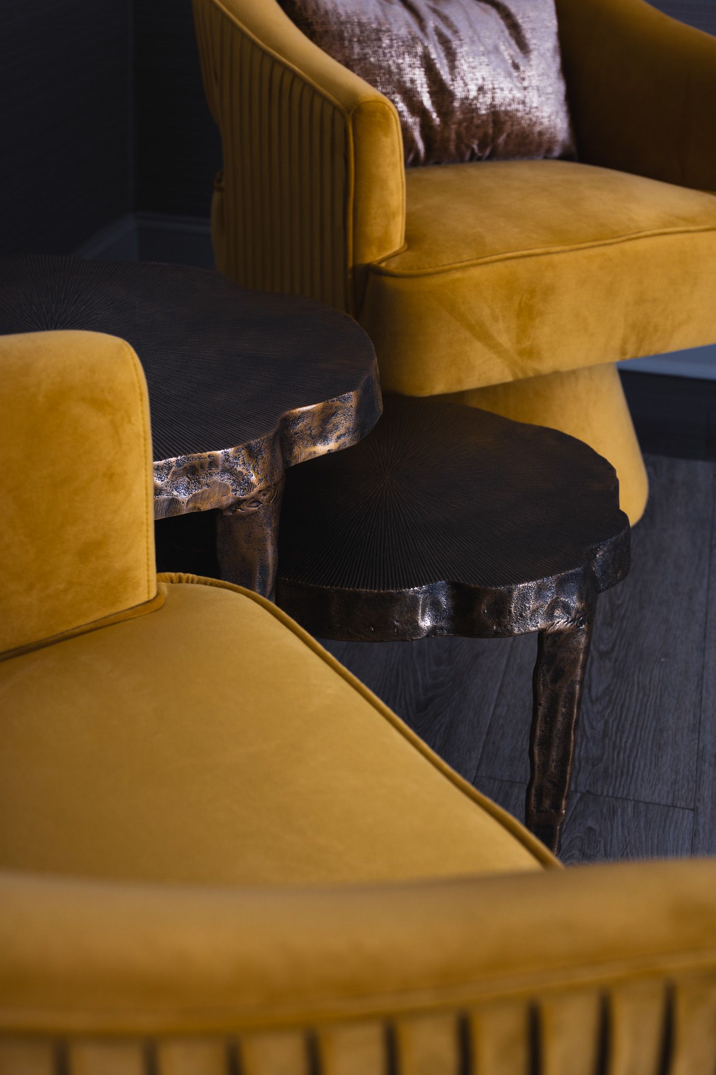 yellow plush armchairs and textured metal side table