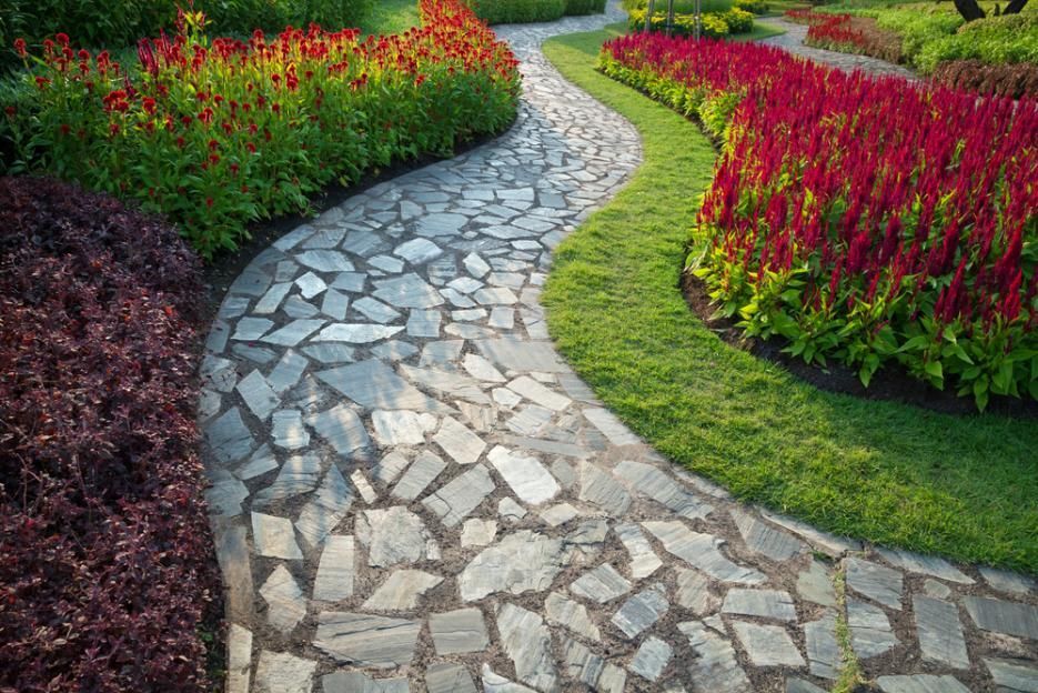 A Stone Walkway In A Garden Surrounded By Flowers And Grass — Southern Bricks & Pavers In Ulladulla, NSW