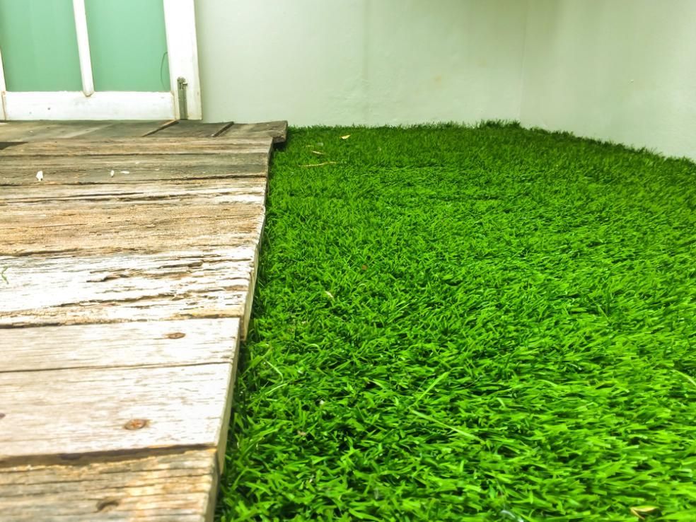 A Wooden Walkway Leading To A Lush Green Field Of Grass — Southern Bricks & Pavers In Ulladulla, NSW