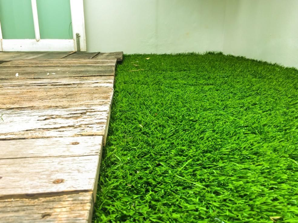 A Wooden Walkway Leading To A Lush Green Field Of Grass — Southern Bricks & Pavers In Narooma, NSW