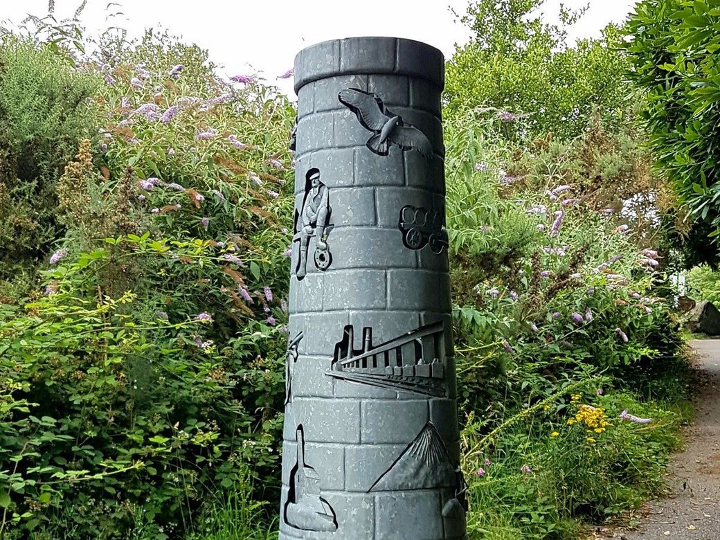 Chimney sculpture featuring depictions of Cornish mining heritage at Wheal Martyn St Austell