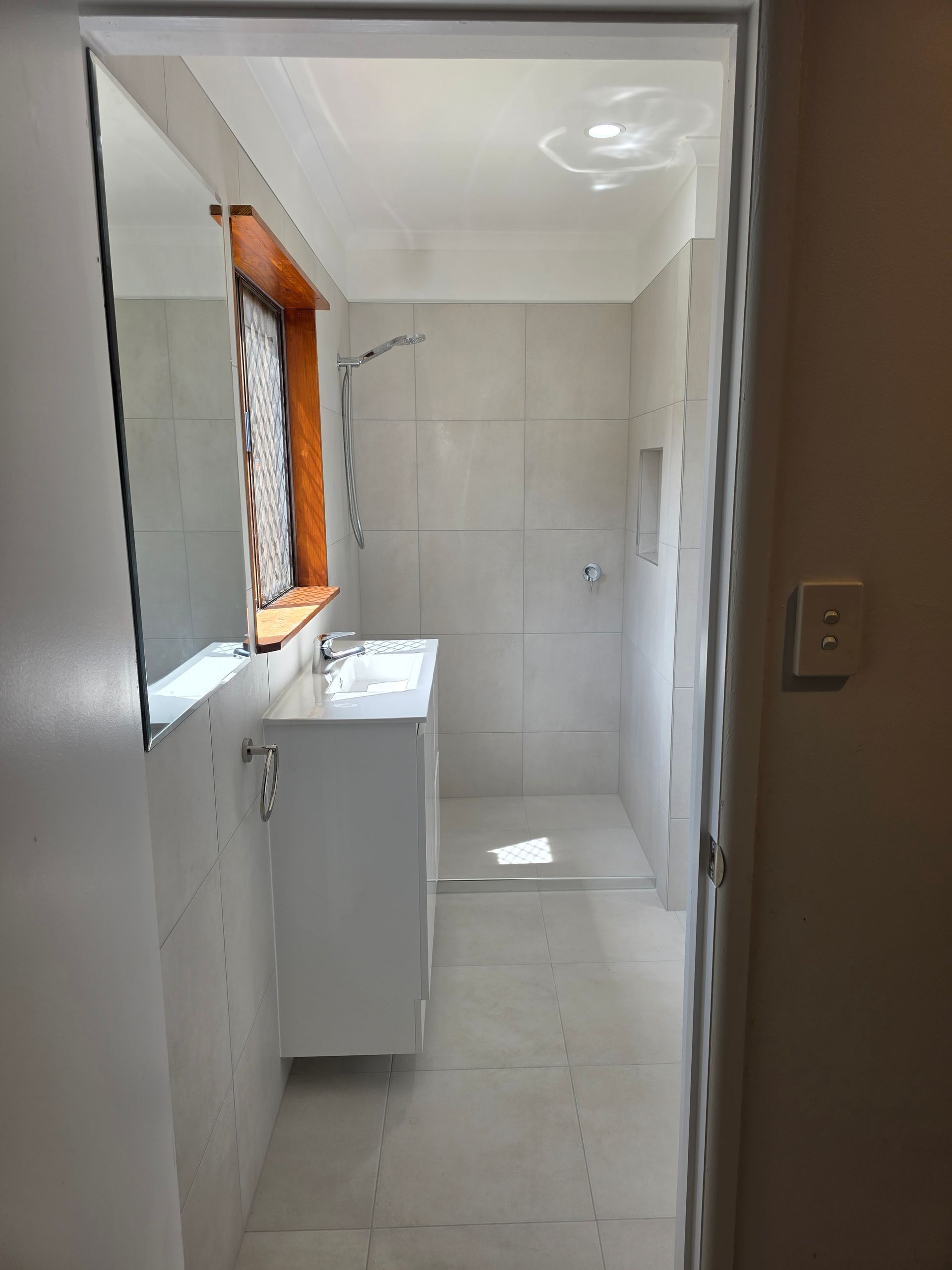 Narrow Tiled Bathroom With a Window — Done Right Bathrooms And Renovations in Edmonton, QLD