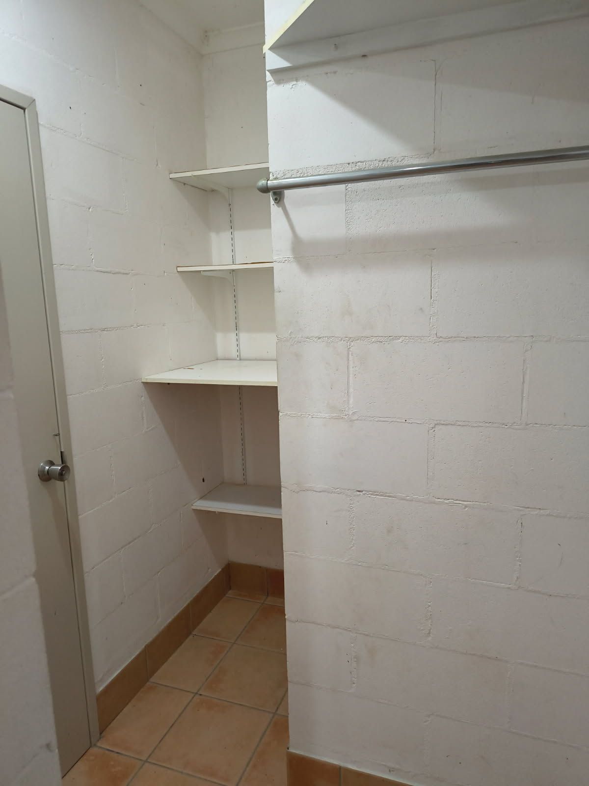 A Closet Interior Featuring White Painted Cinder Block Walls — Done Right Bathrooms And Renovations in Edmonton, QLD