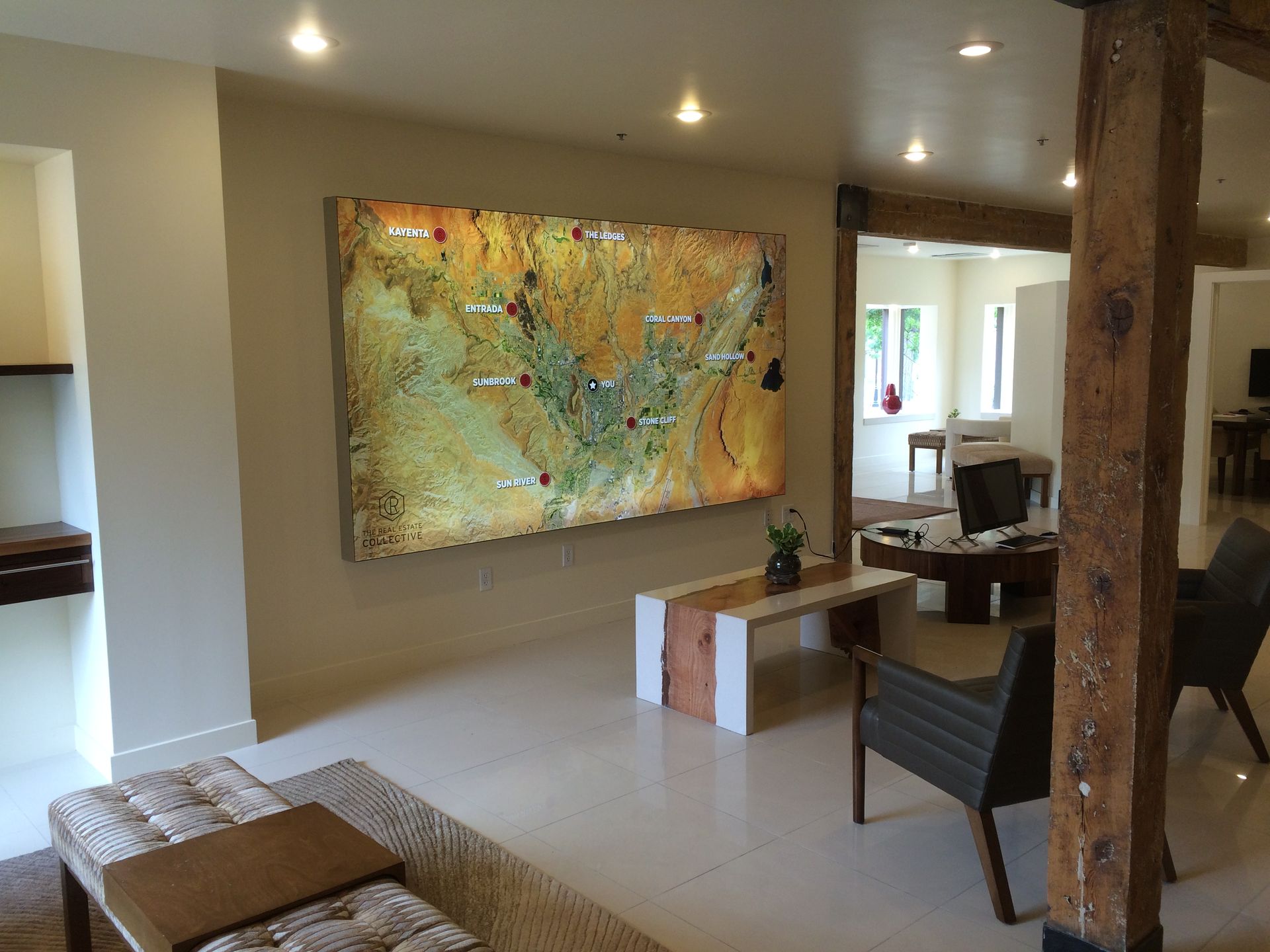 A living room featuring a stone fireplace with a mounted television, flanked by white built-in shelves displaying decor.