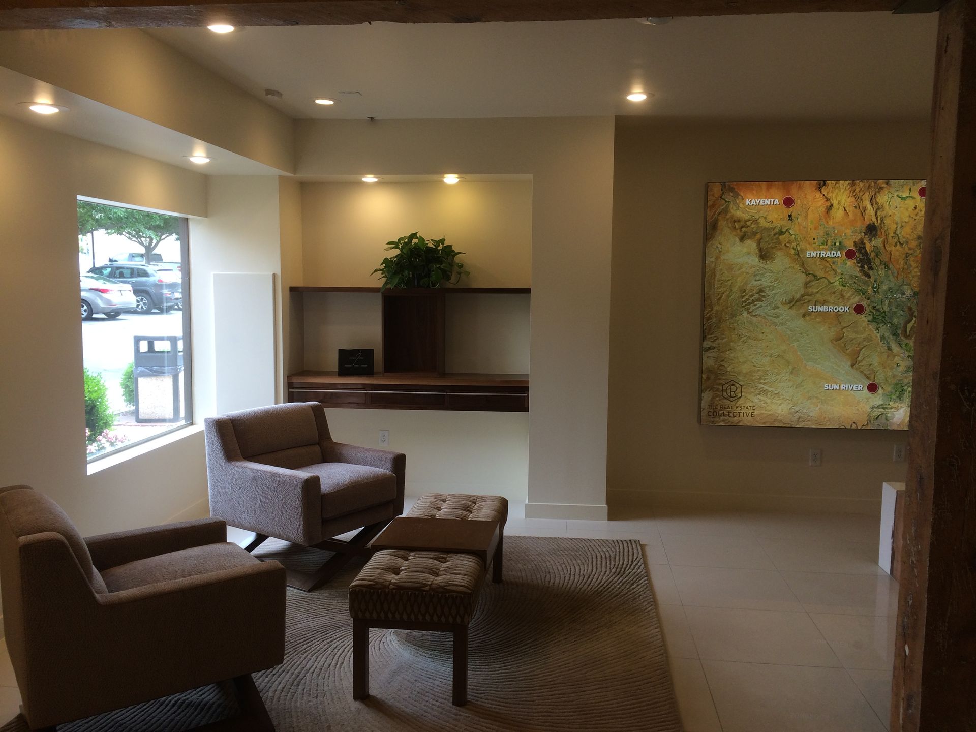 White custom built-in shelves surround a fireplace with a mounted television area and a ceiling fan overhead.