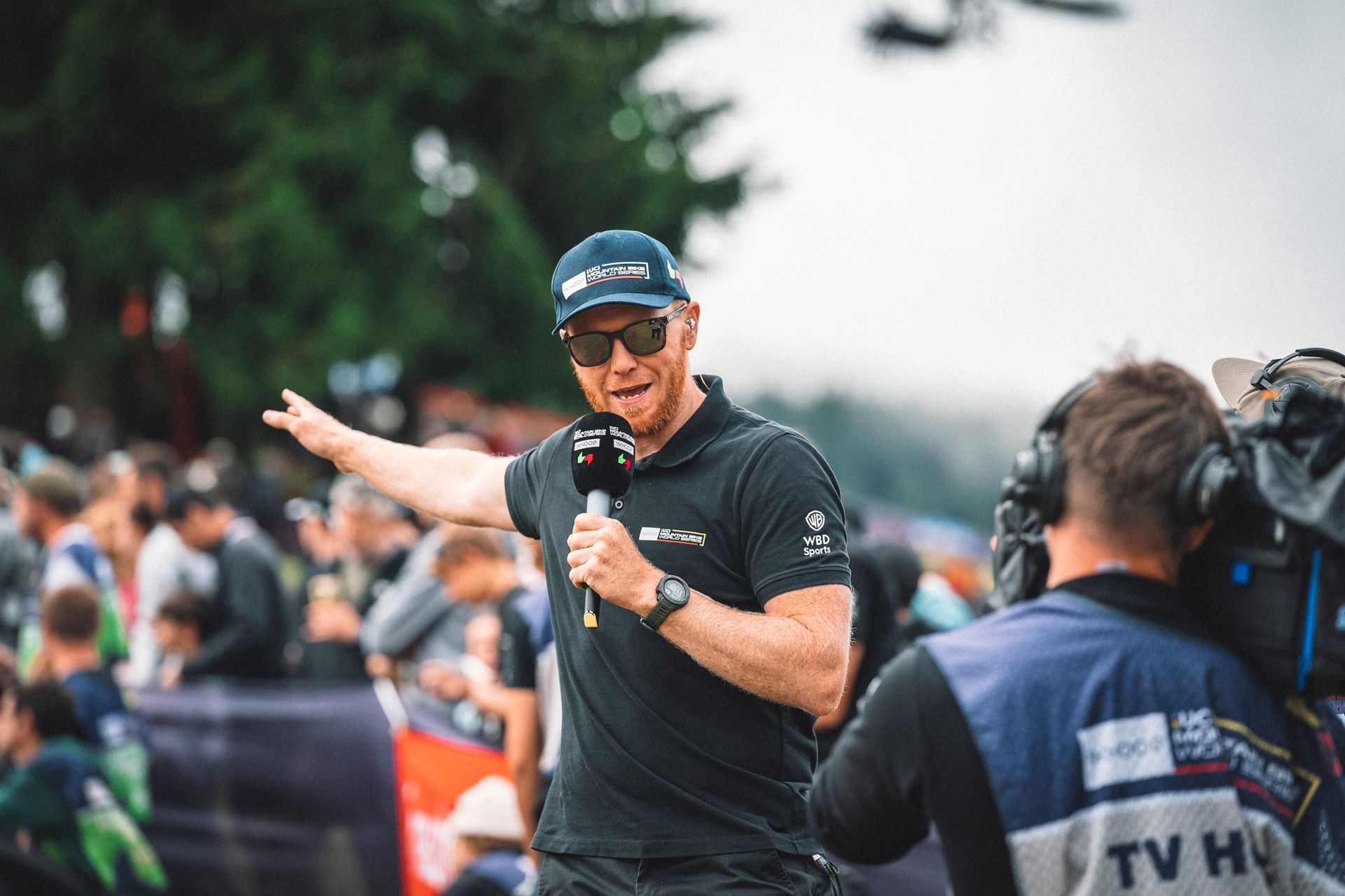 A man is holding a microphone in front of a crowd of people.