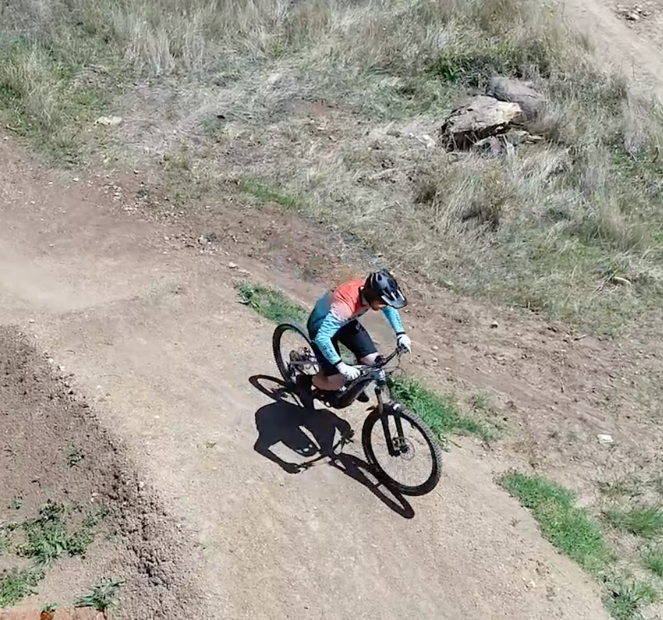 A person is riding a bike down a dirt road.