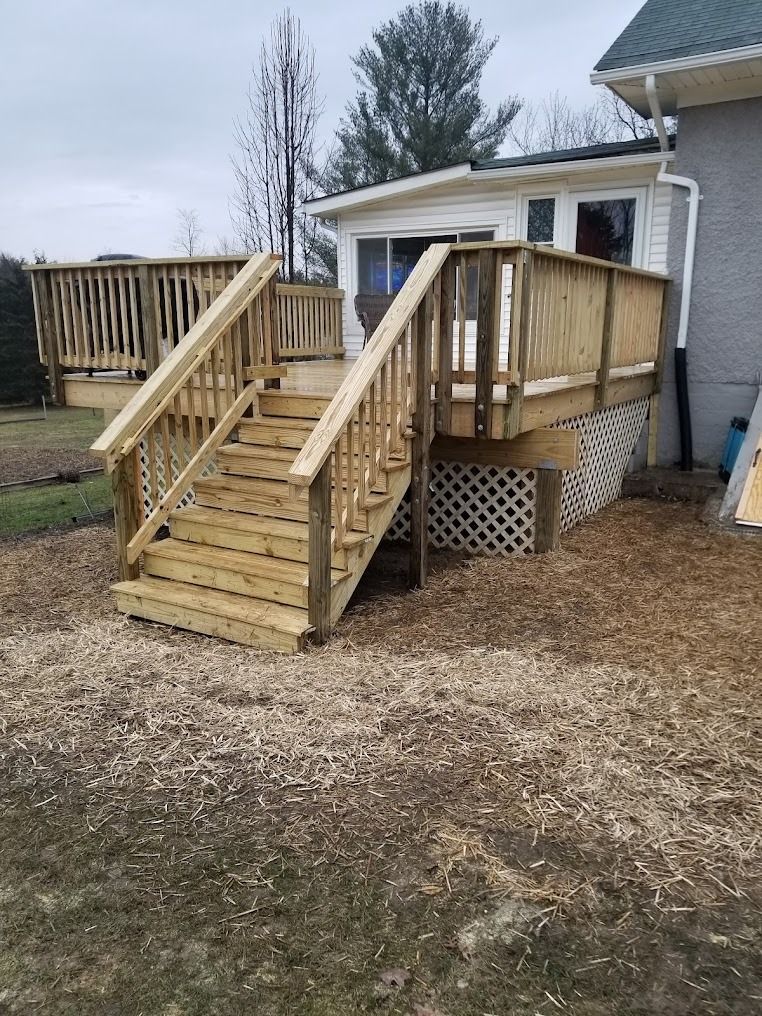 Wooden backyard ramp and steps leading to a raised porch beside a house