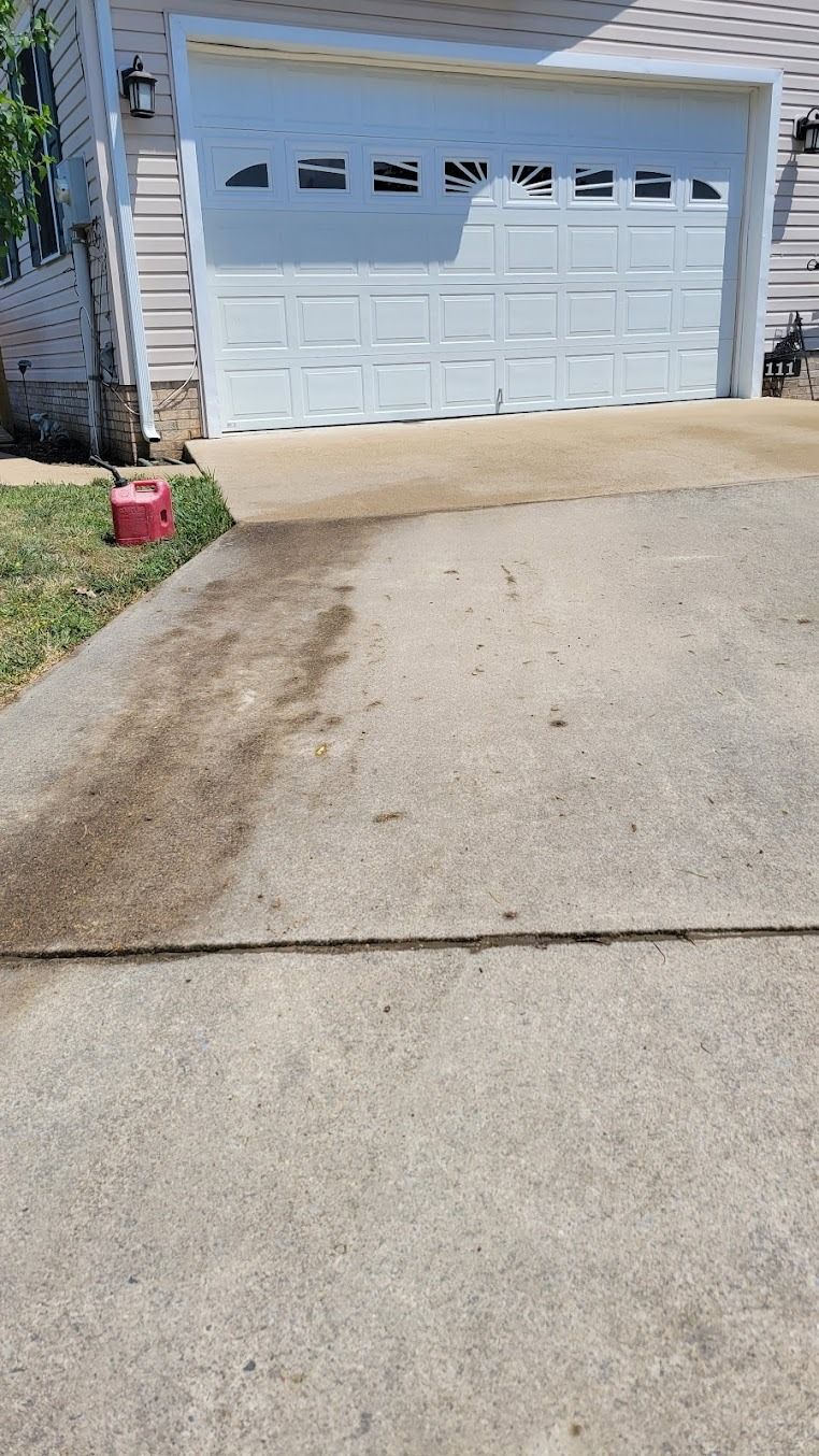 Concrete driveway leading to a white garage door on a suburban house