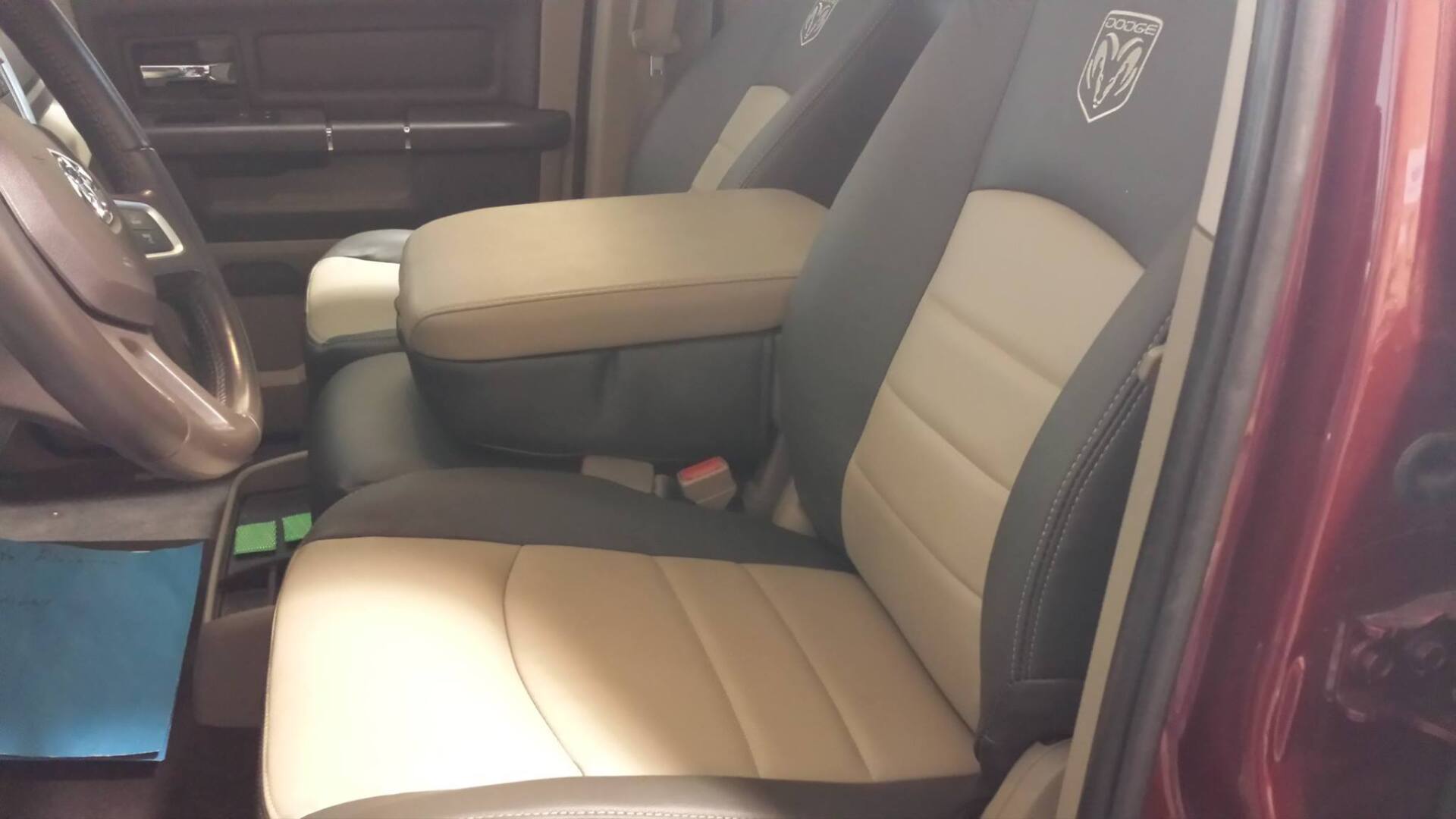 A red truck with tan and black seats and a steering wheel