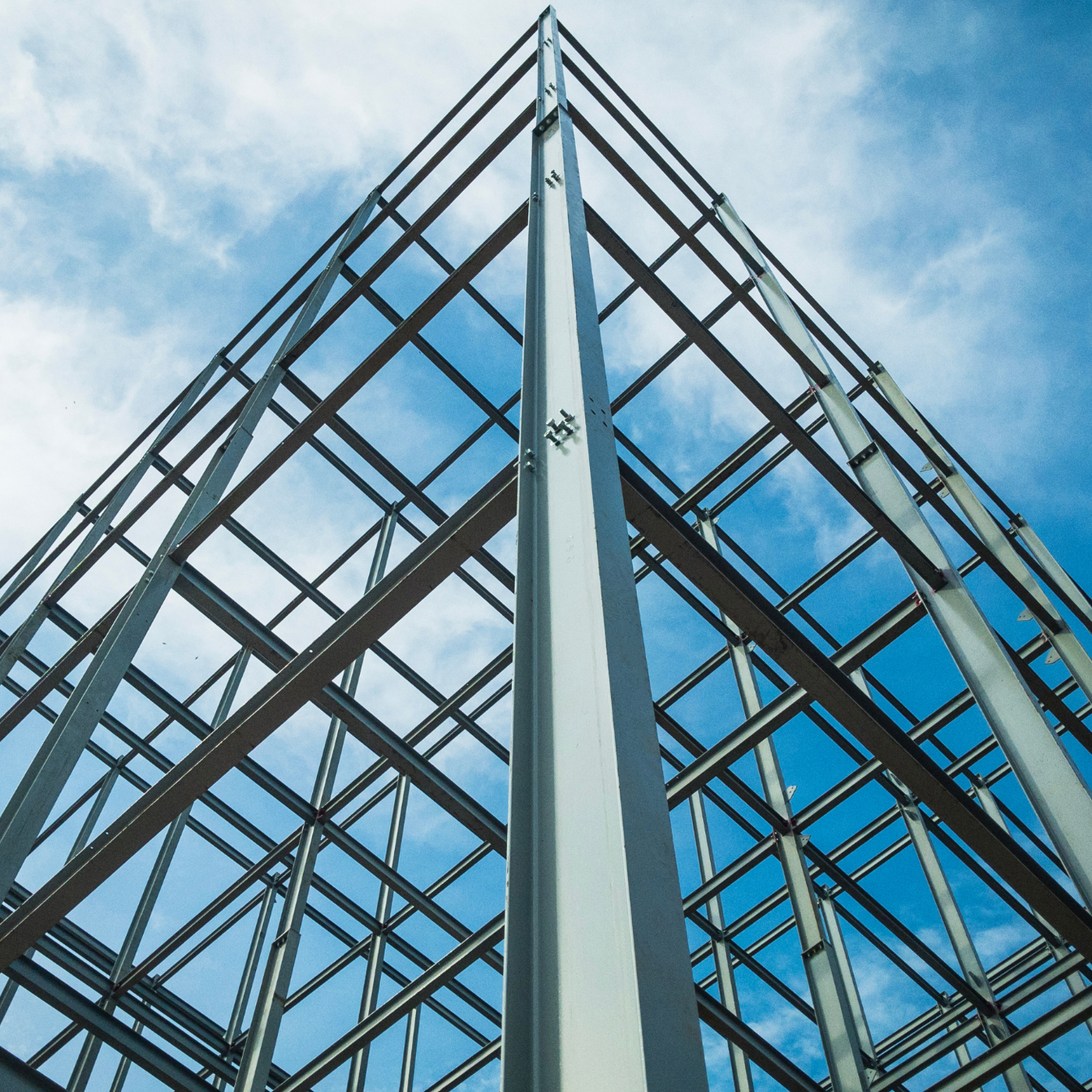 Modern glass-and-steel building facade against a blue sky