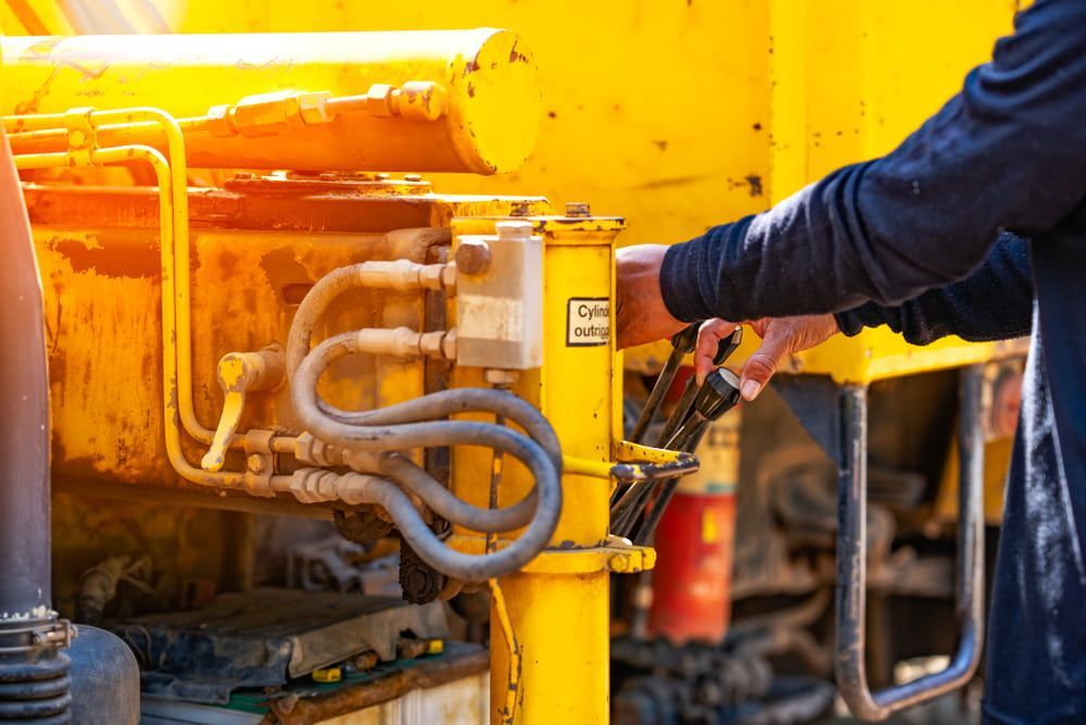A Man is Working on a Yellow Hydraulic Machine — Grafton Hydraulics in South Grafton, NSW