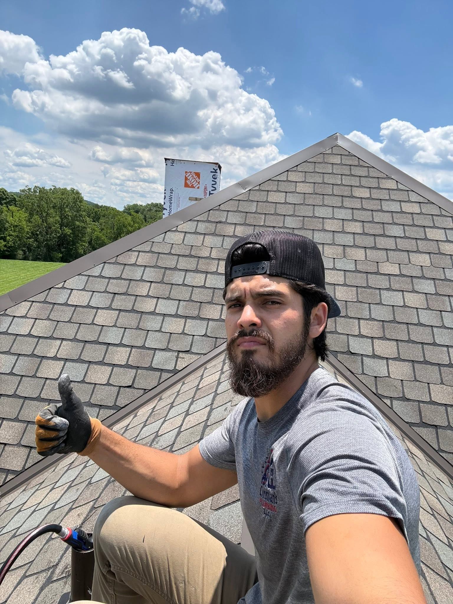 Selfie of a man on a rooftop giving a thumbs-up under a cloudy sky