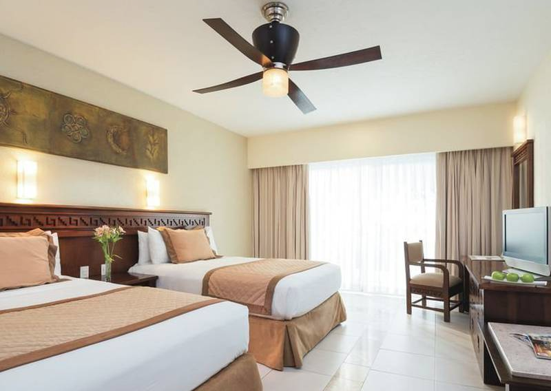 Una habitación de hotel con dos camas y un ventilador de techo
