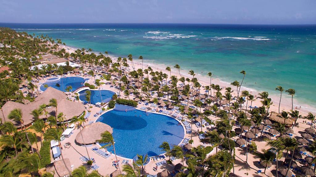 Una vista aérea de una playa con palmeras y una gran piscina.