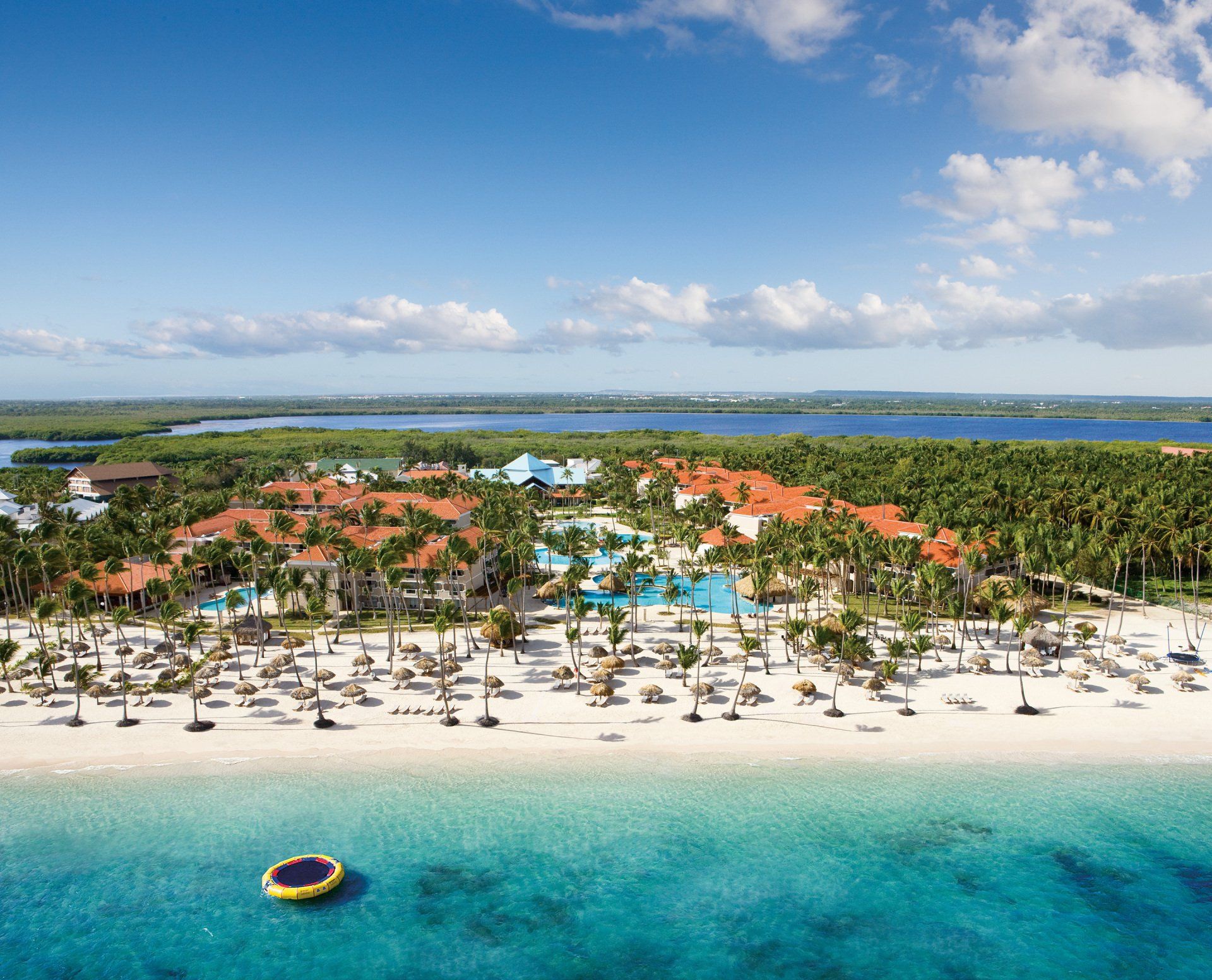Una vista aérea de un resort de playa con una balsa en el agua.