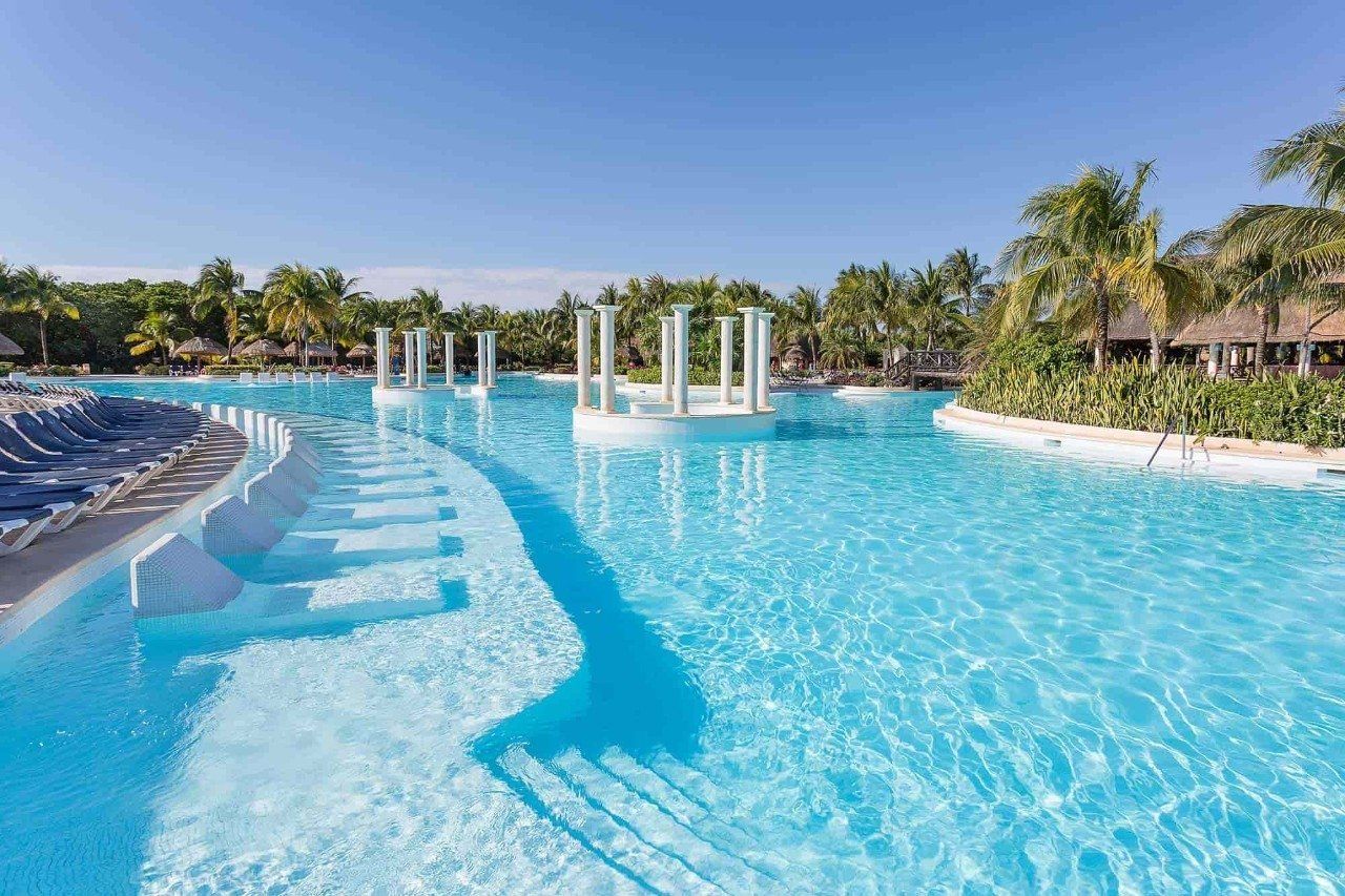Una gran piscina rodeada de palmeras en un resort.
