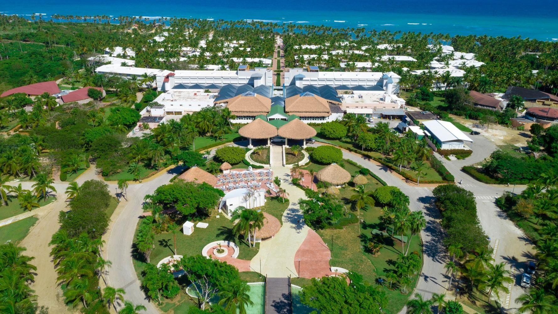 Una vista aérea de un resort tropical rodeado de árboles y palmeras.