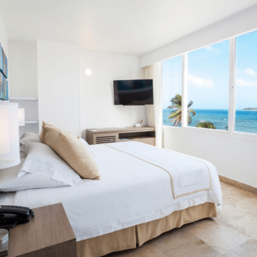 Una habitación de hotel con una cama king size y un televisor de pantalla plana