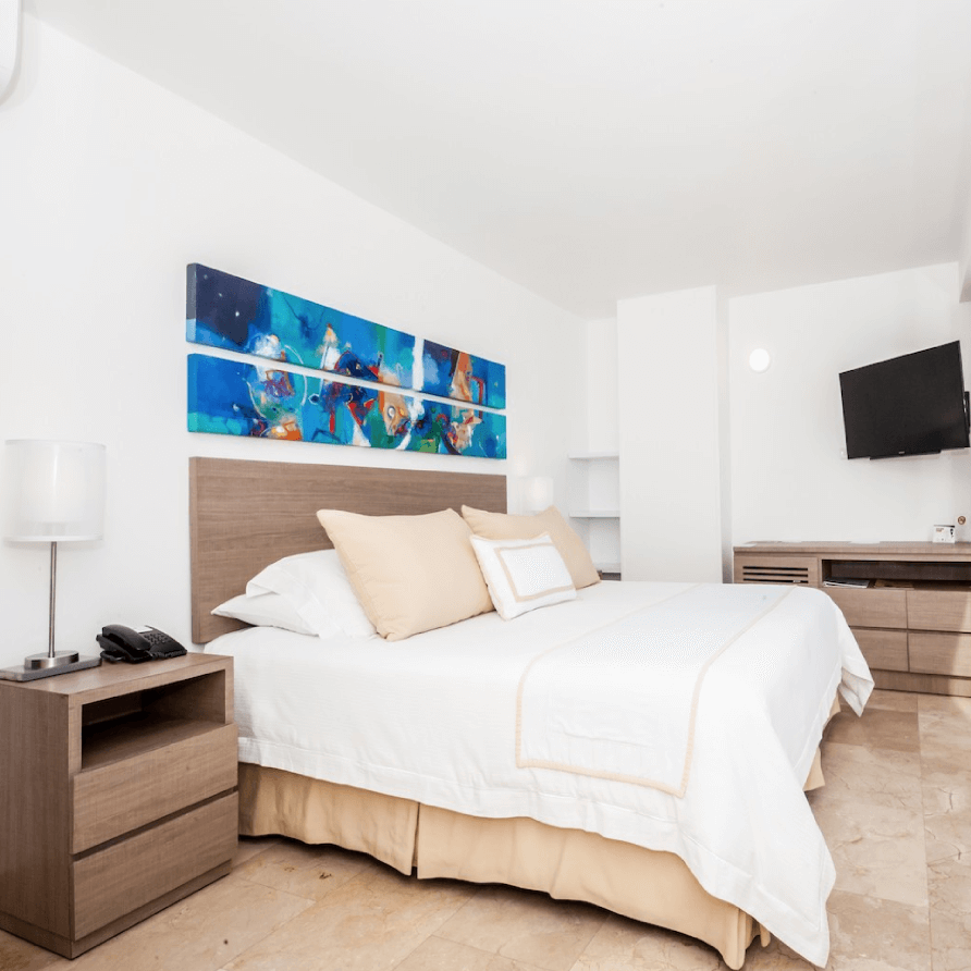 Una habitación de hotel con una cama king size y un televisor