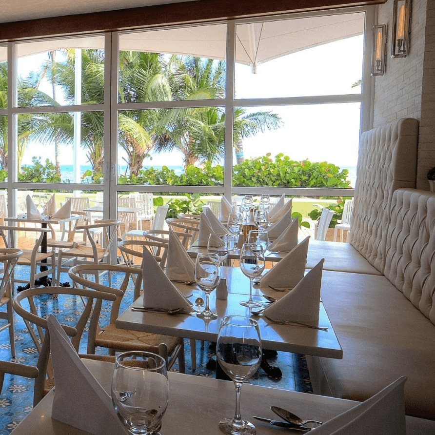 Un restaurante con mesas y sillas y vista al mar