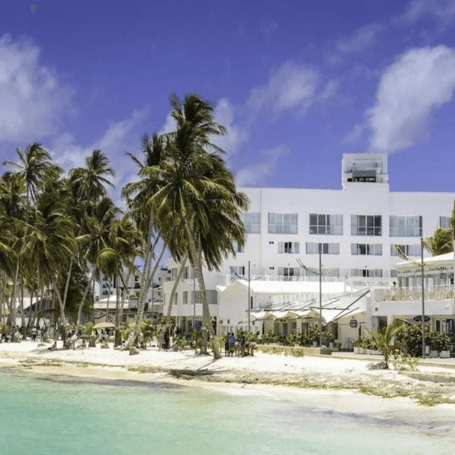 Un gran edificio blanco con palmeras frente a él