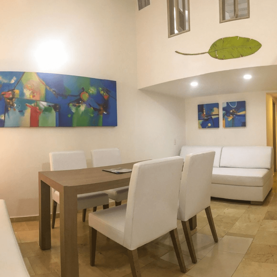 Una sala de estar con mesa y sillas y un cuadro en la pared