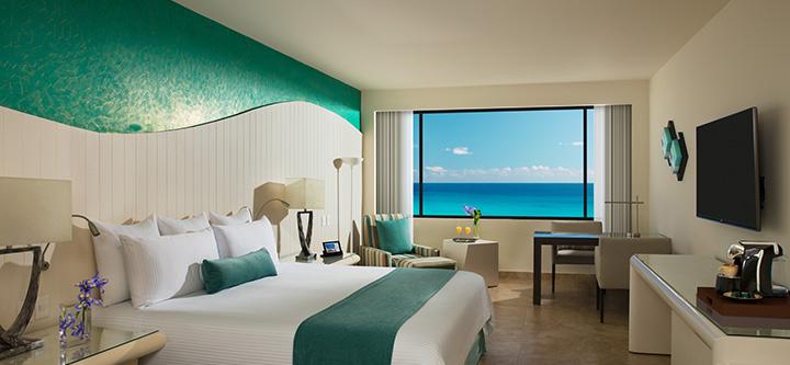 Una habitación de hotel con una cama grande y un gran ventanal con vistas al océano.