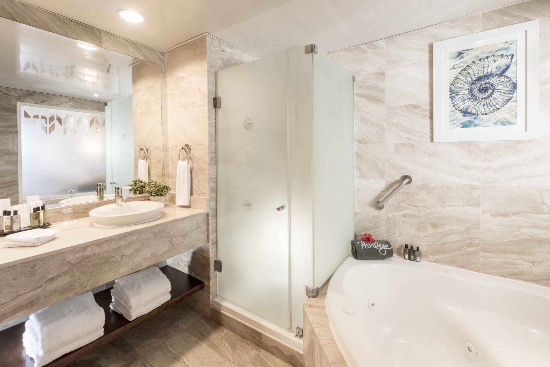 Un baño en una habitación de hotel con bañera, lavabo y ducha.