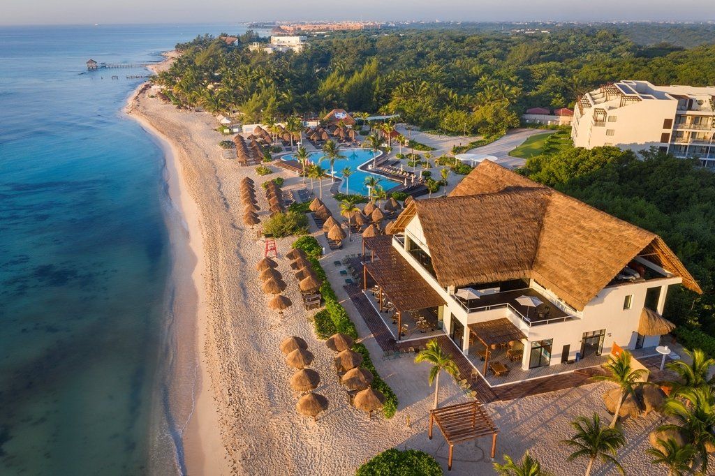 Una vista aérea de un resort de playa con techo de paja.