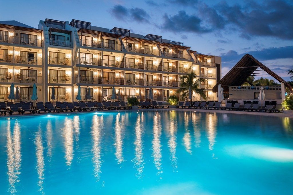 Un gran hotel con una gran piscina enfrente.