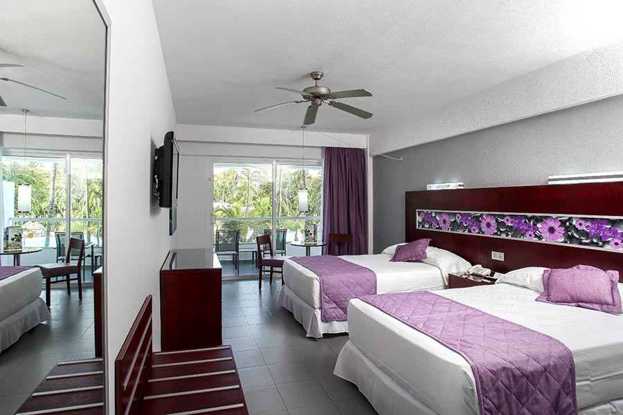 Una habitación de hotel con dos camas y ventilador de techo.