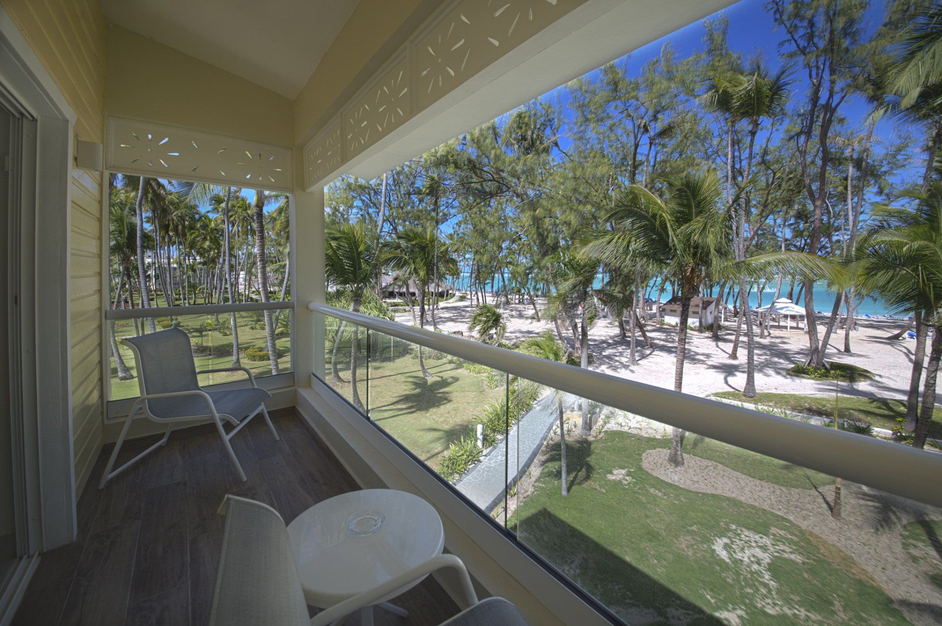 Un balcón con sillas , una mesa y vista a la playa.