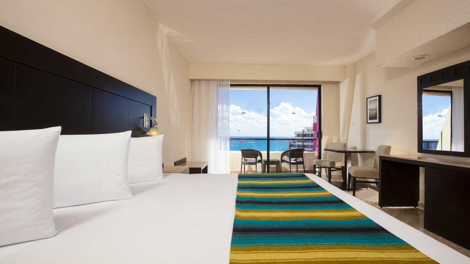 Una habitación de hotel con cama king size y vista al mar.