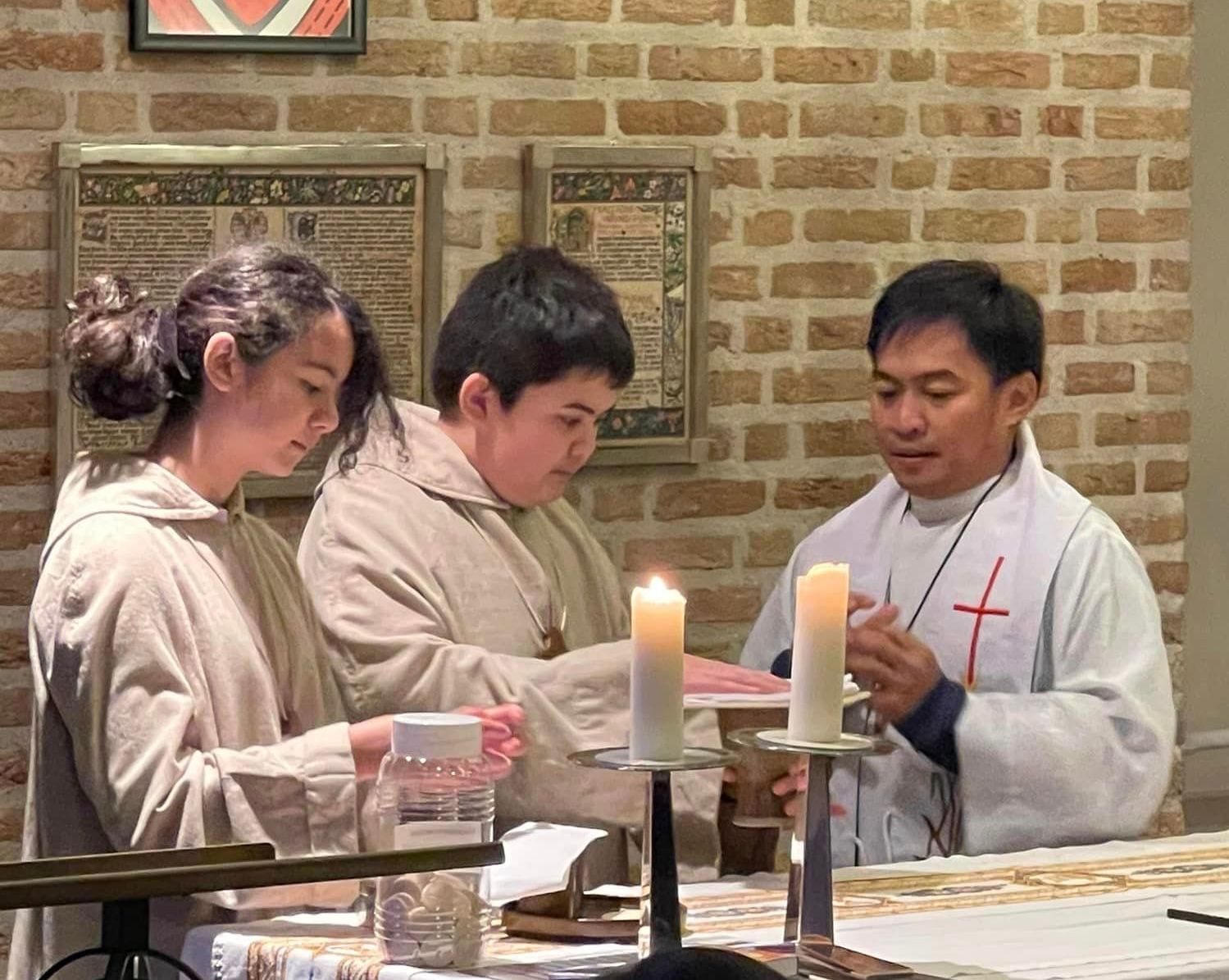 A group of people are sitting at a table with candles in front of them.