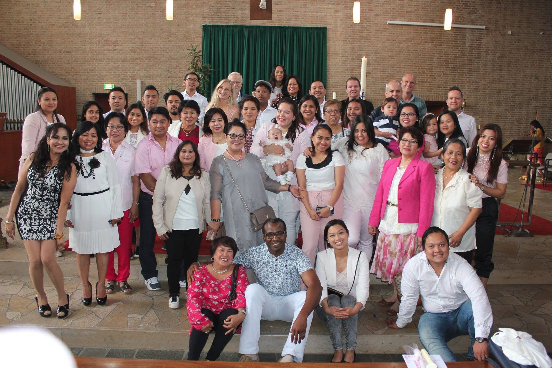 A large group of people are posing for a picture in a church.