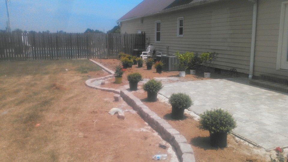A house with a patio and potted plants in front of it.