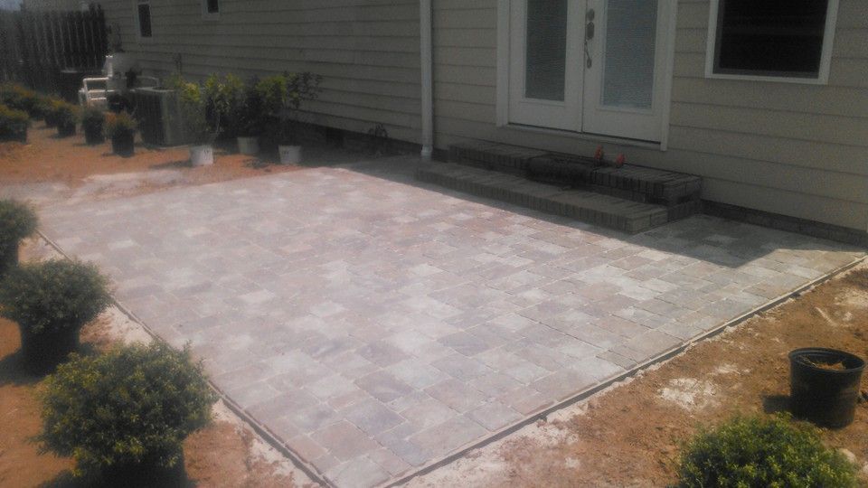 A patio is being built in front of a house.