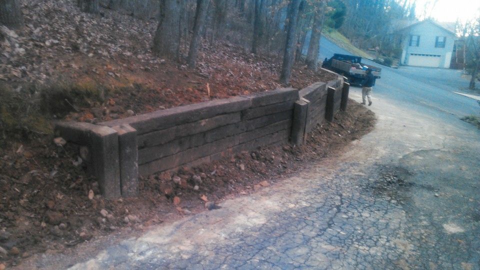 A wooden fence along the side of a road next to a house.