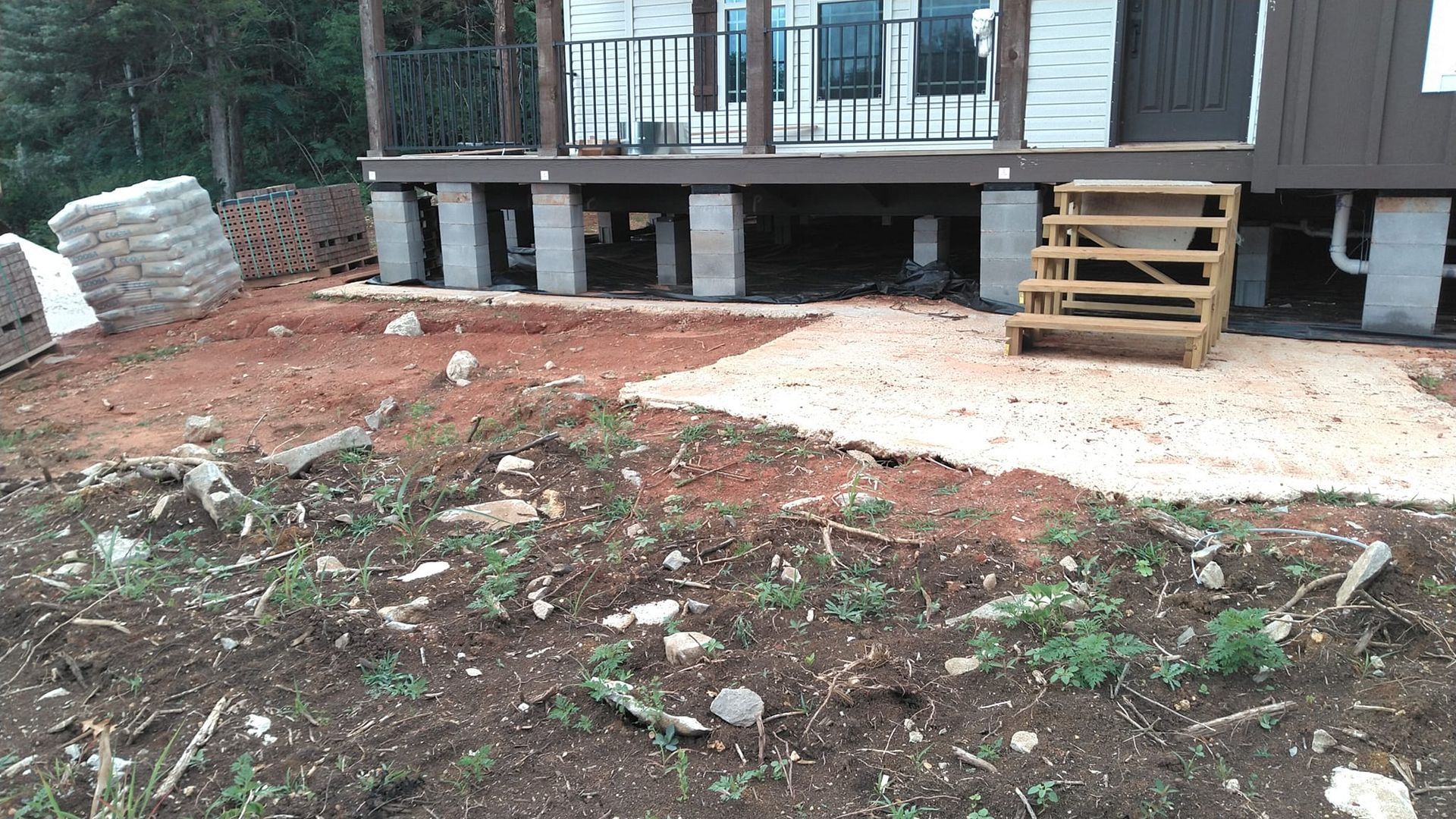 A house is being built on stilts with a deck and stairs.