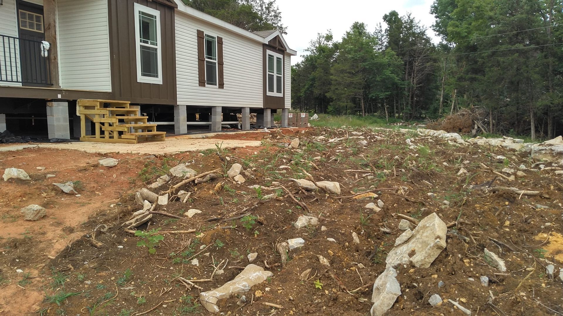 A mobile home is sitting on top of a dirt hill.