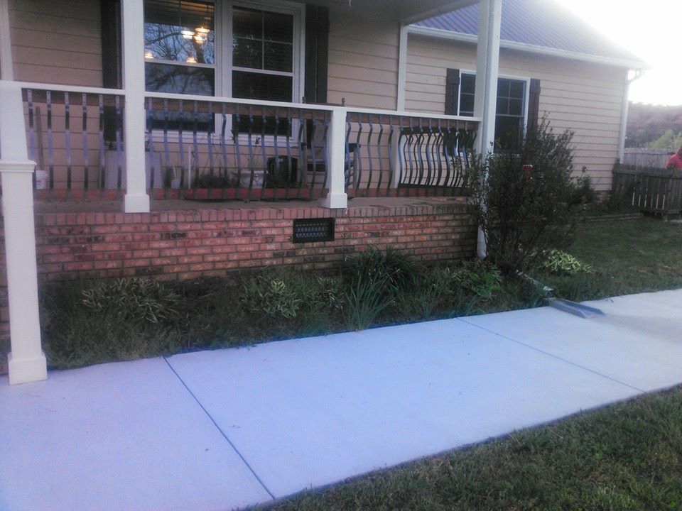 A house with a porch and a sidewalk in front of it