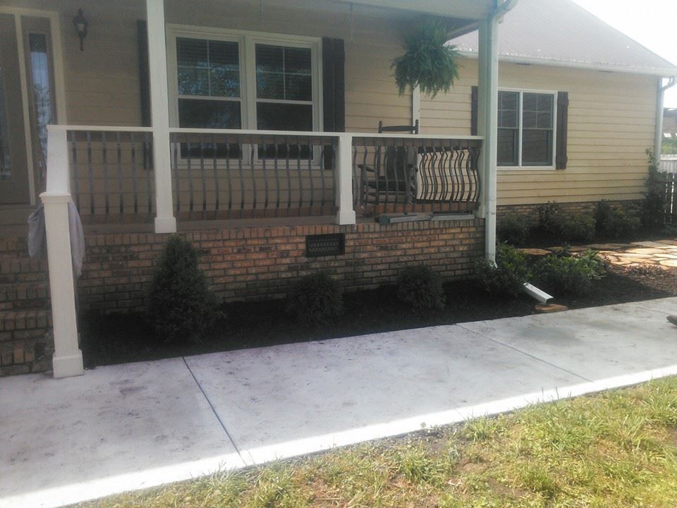 A house with a porch and a brick wall