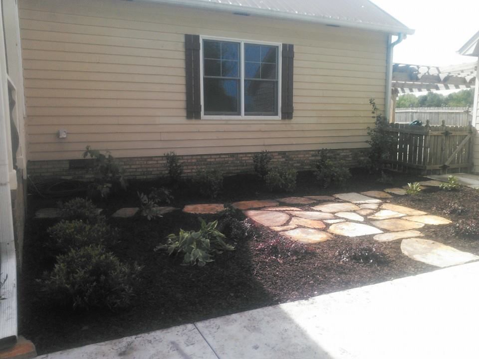 A house with a stone walkway in front of it.