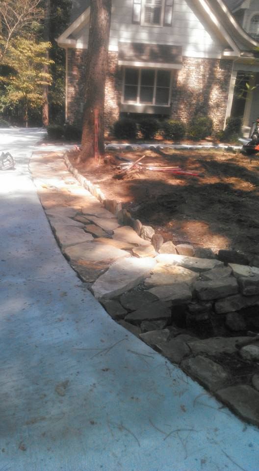 A stone walkway is being built in front of a house.