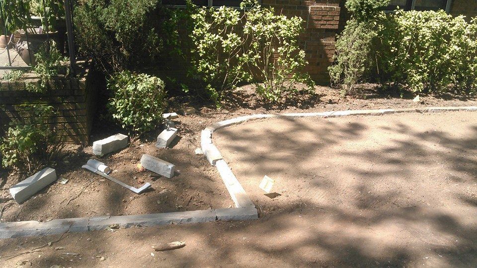 A concrete curb is being installed on a dirt road