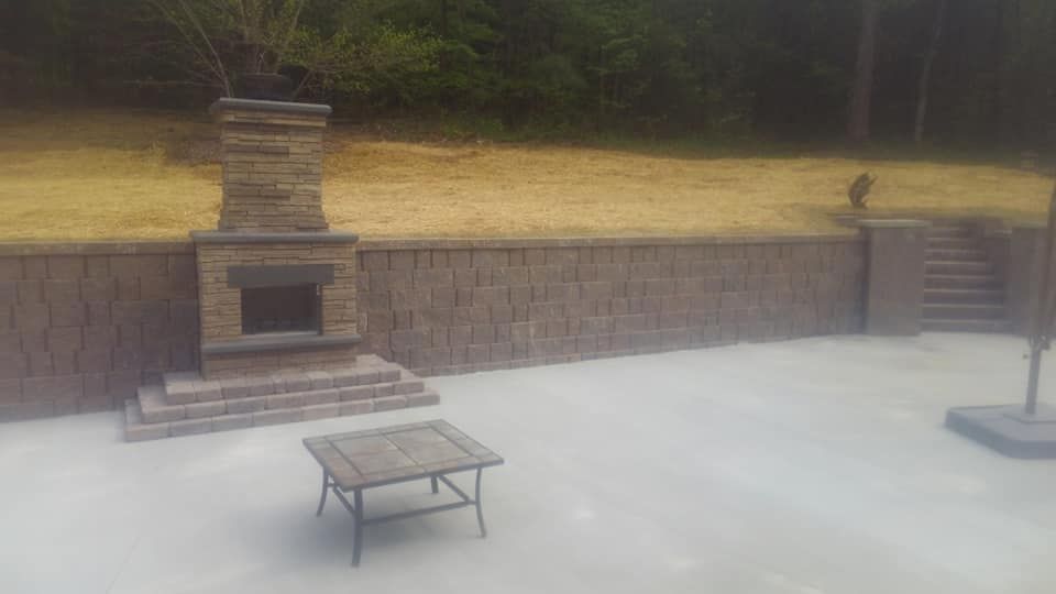 There is a fireplace and a coffee table in the backyard.