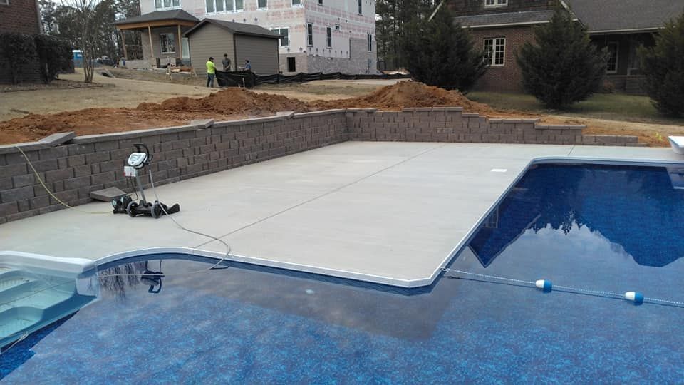 A large swimming pool is being built in the backyard of a house.